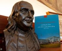image of bust of benjamin franklin beside a book