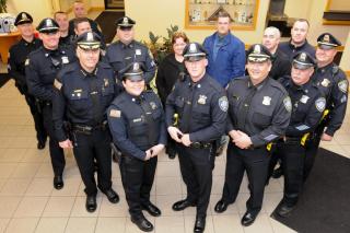 New officers Jack Flynn and Tara Souza surrounded by officers who came to support them during their swearing in