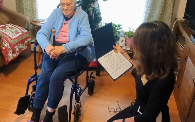 Mrs. DiMartino being [presented the Boston Post Cane at a celebration in her home on December 7, 2023